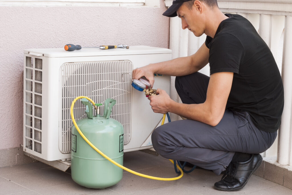 Técnico dando mantenimiento a unidad de aire acondicionado