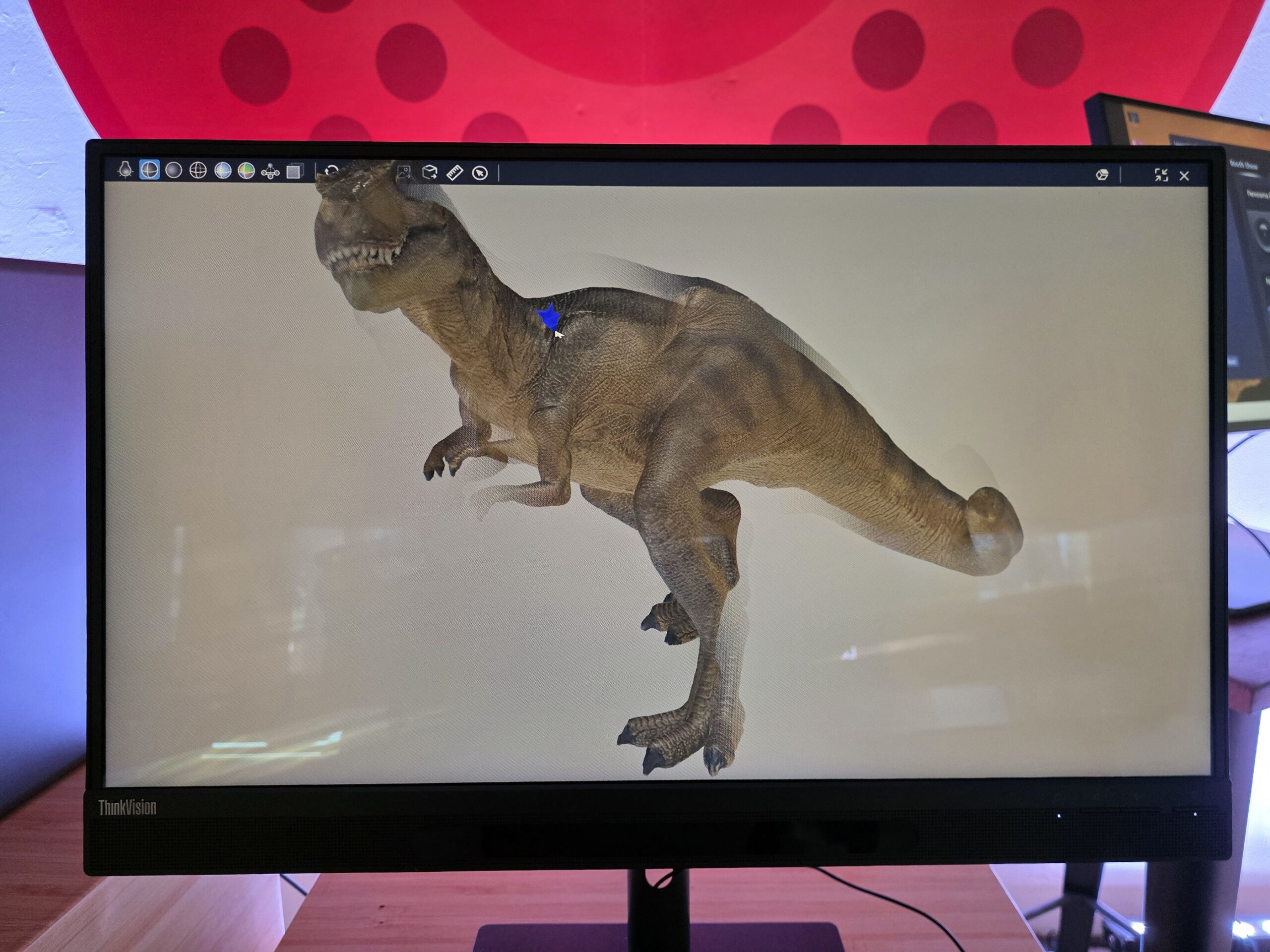 Lenovo ThinkVision 27 3D, se observa el efecto 3D del tiranosaurio como saliendo de la pantalla, y desde la ventana del software. 
