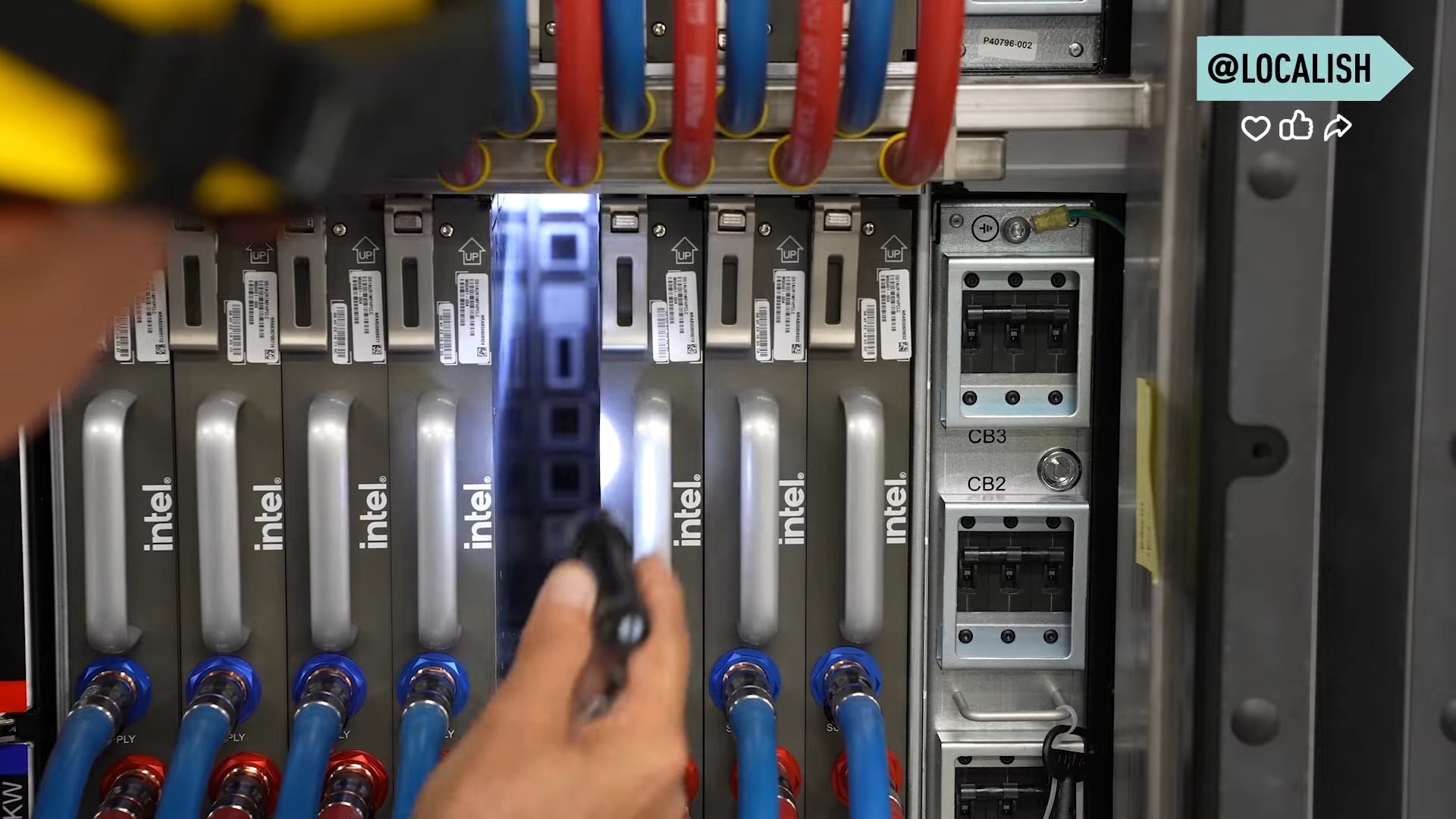 Detalle de un módulo de cómputo de Aurora. Cada unidad contiene componentes Intel de alto rendimiento, conectados a un sistema de enfriamiento líquido de circuito cerrado. Los tubos azules y rojos gestionan el flujo térmico, mientras que las manijas permiten el acceso físico para mantenimiento o reemplazo.